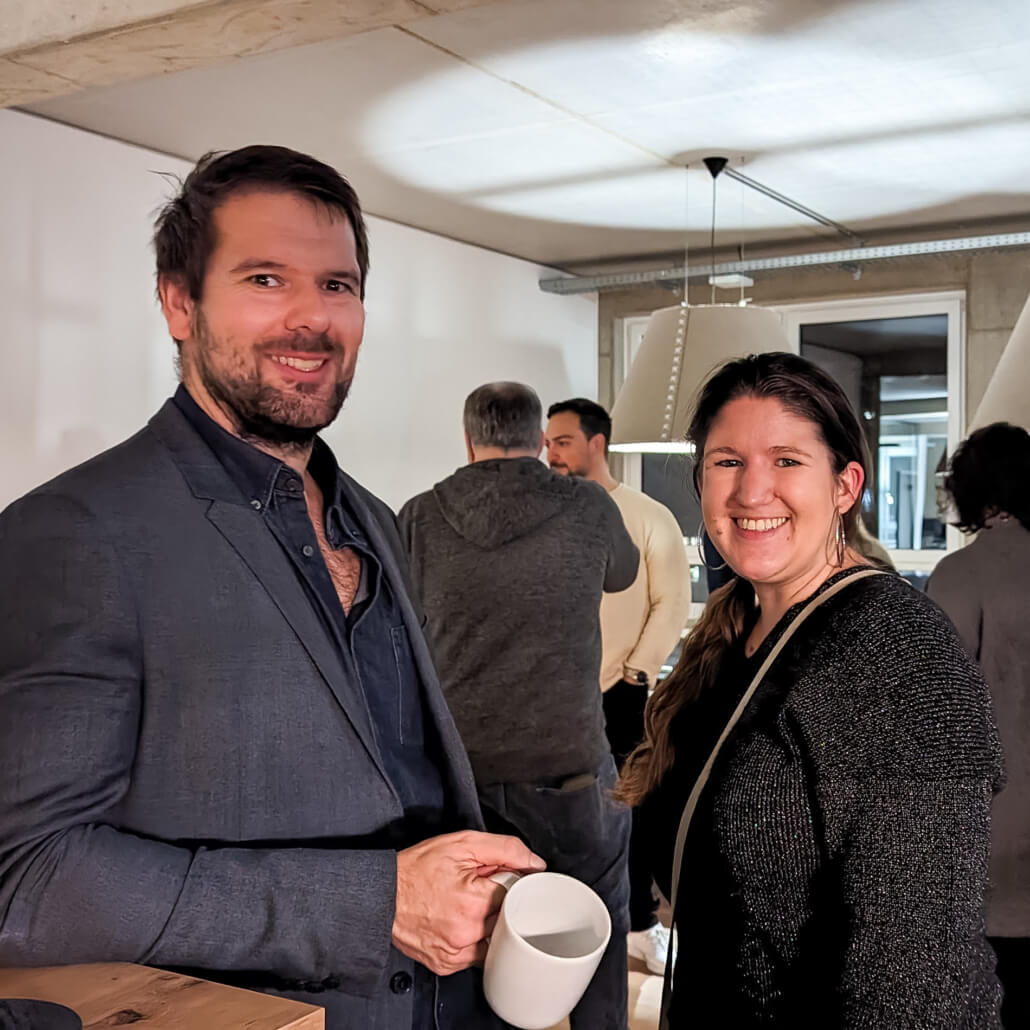 Das Team lässt es sich an der Weihnachtsfeier im neuen Büro gut gehen.