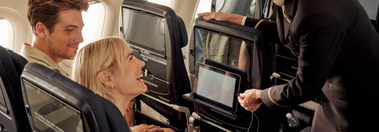 Condormitarbeiterin interagiert mit Kunden im Flugzeug